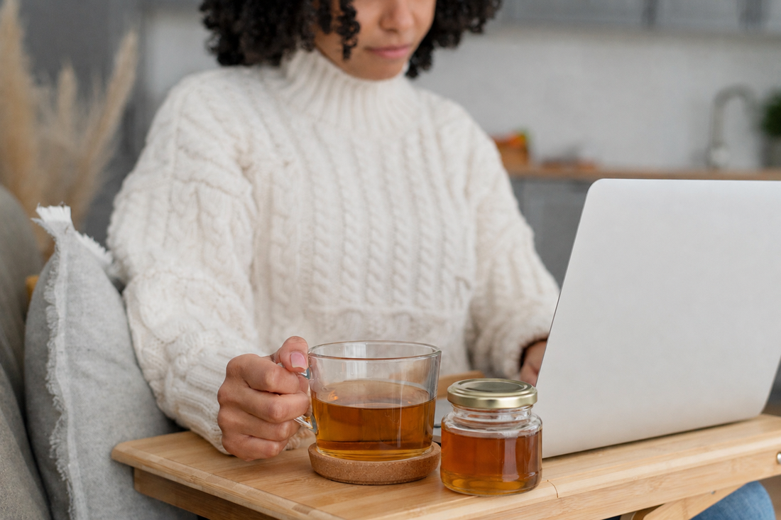 Frau kauft online Honig und trinkt Tee neben einem Glas Honig