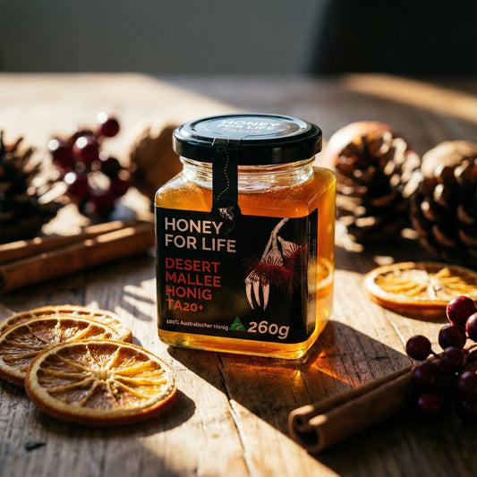 A jar of honey for life under the ray of sunlight with dried slice of lemon and pinecones on the table.