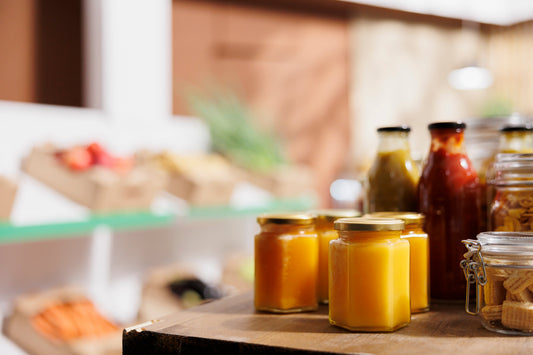 Verschiedene Honiggläser und Lebensmittel in einem Schweizer Verkaufsregal – Vergleich von Supermarkt-Honig und Premium-Honig