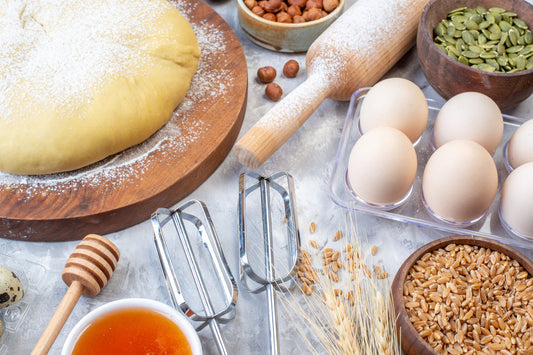 side view raw pastry flour round board grater fresh fruits eggs honey gray background