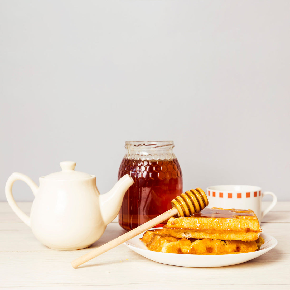 traditional belgium soft fresh waffles with honey teapot table