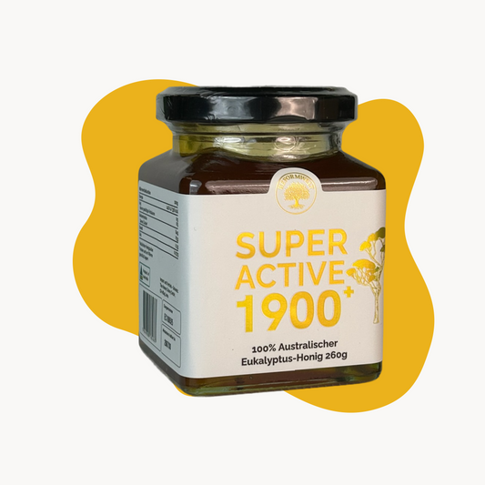 Reformwelt Super Active 1900+ australischer Eukalyptus-Honig im 260g Glas mit schwarzem Deckel vor gelbem Hintergrund.