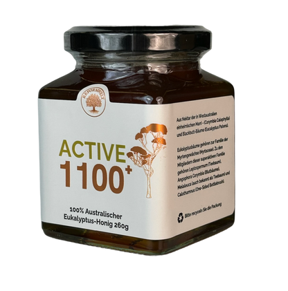 Glas Active 1100+ australischer Eukalyptus-Honig, schräg von der Seite mit cremefarbenem Etikett und Produktbeschreibung.