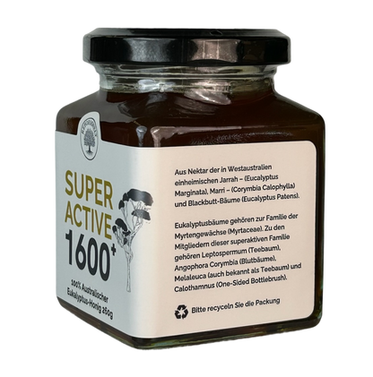Glas mit Super Active 1600+ australischem Eukalyptus-Honig, schwarzem Deckel und cremefarbenem Etikett, schräg von der Seite auf transparentem Hintergrund dargestellt.