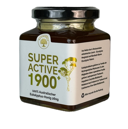 Glass jar of Super Active 1900+ Australian eucalyptus honey with a black lid and cream label, shown from the front at a slight angle on a transparent background.